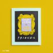 A framed print with a yellow border on a yellow wall features the phrase "WELCOME TO THE REAL WORLD. IT SUCKS. YOU'RE GONNA LOVE IT!" inside a stylized yellow picture frame, and "FRIENDS" written below.