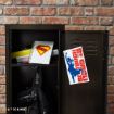 An open locker with a black backpack, notebooks, and a spiral notebook with a red and yellow Superman logo. The locker door has a "Be Tough Be You" poster featuring a blue silhouette of Wonder Woman.