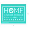 Turquoise sign with white text and paw prints reads: "Home is where someone runs to greet you." The "O" in "HOME" is replaced with a paw print. Sign measures 11 inches by 8.5 inches.