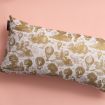 A rectangular pillow with a gold and white vintage hot air balloon and landscape print rests on a pale pink background.