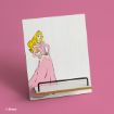 A phone or tablet stand featuring an illustration of Disney's Princess Aurora in a pink dress, set against a white wooden background with a pink surface underneath.