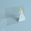 A clear acrylic stand features an illustration of Cinderella in her blue ball gown on the right side. The stand is set against a light blue background. © Disney.