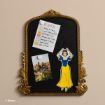A decorative gold-framed blackboard displays a colorful weekly schedule, a photo of people in a field, and a cutout illustration of Snow White holding her bow. © Disney.
