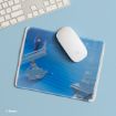 A white computer mouse on a mouse pad featuring Cinderella running down blue palace stairs, with her glass slipper left behind. A keyboard is partially visible on the light blue desk. Disney copyright is in the corner.