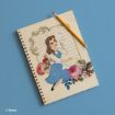 A spiral notebook with an illustration of Belle from Disney’s "Beauty and the Beast," sitting in a blue dress, surrounded by colorful flowers, with a pencil resting on top. The background is a solid light blue.