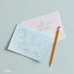 A light blue card and a white envelope, both illustrated with Cinderella-themed sketches including a carriage, mice, and a glass slipper, are placed next to a yellow pencil on a pale blue surface.