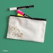 A white pencil case with a gold outline drawing of Pascal the chameleon from Disney, placed on a green surface. The case is unzipped, showing two highlighters and a black marker inside.