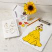 A Disney-themed desk setup with a clipboard featuring Belle in her yellow dress, a notebook with gold Beauty and the Beast sketches, colorful book-shaped pins, a pencil, and a faux sunflower in a white vase.
