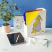 A desk with a potted plant, a folder holder decorated with Rapunzel, colorful folders, a pouch with Pascal the chameleon, a digital tablet with stylus, and a card featuring Rapunzel and Pascal.