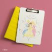 A clipboard with an illustration of three Disney princesses is placed on top of a yellow binder against a pink background. The princesses wear blue, yellow, and pink dresses. Disney copyright is noted in the corner.