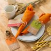 A festive table setting with gold cutlery, stacked white plates, orange napkins tied with twine, tags reading “Happy Thanksgiving,” “Happy Fall Y’all,” and “Gobble till you wobble,” plus wheat stalks and a white mug.