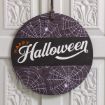 A round sign with purple spider webs and the words "Happy Halloween" in orange and white, hanging on a white door with decorative molding.