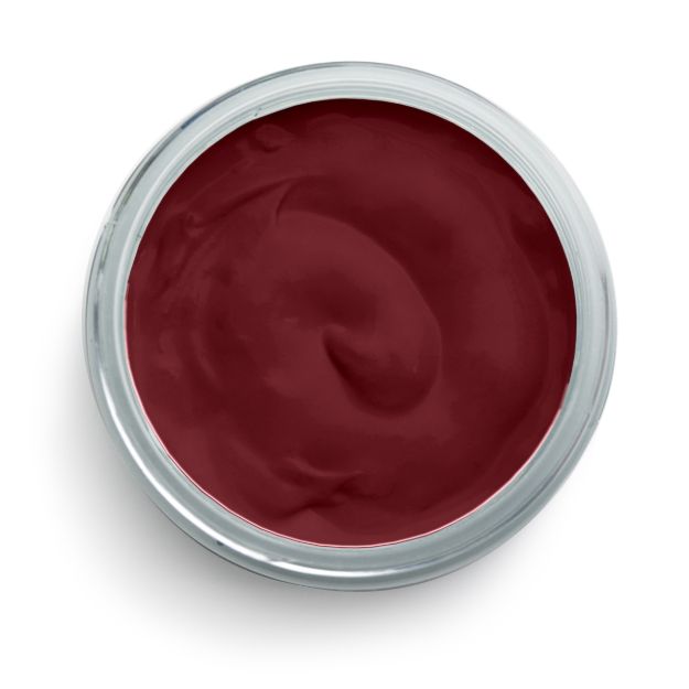 A round, open container filled with smooth, dark red cream or paste, viewed from above against a white background.