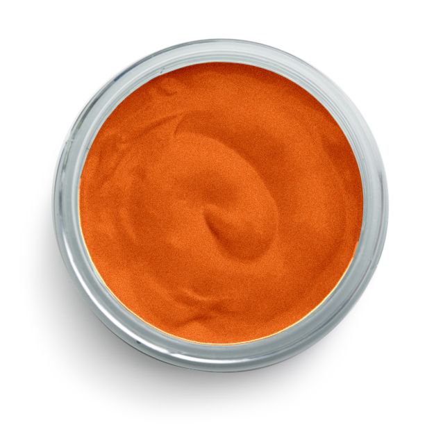 A glass bowl filled with smooth, orange-colored sauce or dip, viewed from above against a white background.