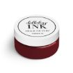 A small round jar with a white lid labeled "Chalkology Ink, Chalk Couture, Permanent Ink," containing deep red ink.