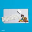 A white keyboard and mouse on a desk mat featuring Mickey Mouse in a fall outfit with pumpkins and leaves. The mat is on a bright blue surface.