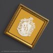 A gold ornate frame contains the Hufflepuff house crest from Harry Potter on a yellow background, featuring a badger and decorative scrollwork.