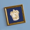 A gold-framed picture featuring the Ravenclaw house crest from Harry Potter on a blue background, showing an eagle and the word "Ravenclaw" beneath the crest.