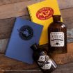 Two spiral notebooks, one blue with "Defence Against the Dark Arts," one yellow with "Hogwarts Flying Lessons," beside two brown glass potion bottles labeled "Potions" and "Charms," displayed on a wooden surface.