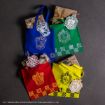 Four colorful tote bags (blue, green, red, yellow) each with a different Hogwarts house crest, sit on a dark surface with matching wrapped gifts and house-themed tags placed near or inside each bag.