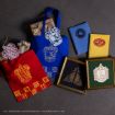 Two tote bags, notebooks, framed prints, and gift boxes with Harry Potter house crests (Gryffindor, Ravenclaw, Hufflepuff, Slytherin) displayed on a dark surface.