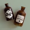 Two brown glass bottles with white vintage-style labels. One reads "Charms" with potion icons, the other "Hogwarts Potions Classes" with icons of a cauldron and books, both referencing Harry Potter.