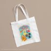 A white tote bag featuring colorful illustrated candy and treats from Honeydukes, inspired by the Harry Potter series, on a neutral beige background.
