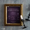 A gold-framed "Midnight Margaritas" recipe print sits on a textured surface, with two black candlesticks—one knocked over—beside it. The print features ingredient illustrations and text on a dark purple background.