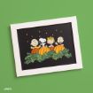 A framed Peanuts illustration featuring four characters and a dog behind pumpkins with stars in the sky, on a green background.
