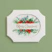 A white-framed sign with watercolor poinsettias and greenery reads “Merry Christmas” in gold script, displayed against a light green wall.