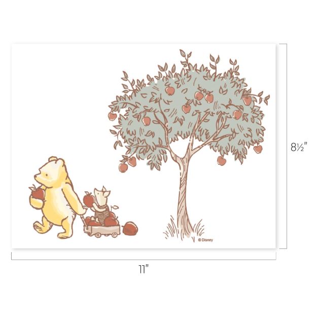 Winnie the Pooh pulls Piglet in a red wagon filled with apples under an apple tree. The image is 11 inches wide and 8.5 inches tall.