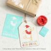 Gift tag and card featuring Winnie the Pooh in a Santa hat next to a wrapped present, red wax seal, and small blue envelope. Both items say “Kinda feels like Christmas” in festive colors.