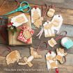 Gift tags featuring Winnie the Pooh characters, honey pots, and Christmas trees are arranged on a wooden table with wrapped presents, scissors, and string.