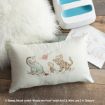 A pillow features line art of Eeyore, Rabbit, and Tigger playing with a flower. Nearby are a fluffy white rug, paper with sketches, and a white item with blue openings. Disney copyright text is visible.
