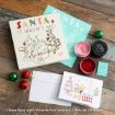 Christmas crafting items featuring Winnie the Pooh and friends, including a card, paper, colored ink pastes, ornaments, and an envelope on a wooden surface. Text at bottom credits Disney and original authors.