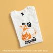 A folded white T-shirt with an illustration of Eeyore holding a pumpkin and text that says, “This is my costume. It’s not much though.” The background is a solid pale orange color.