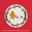 A round tray with Winnie the Pooh and Piglet walking, surrounded by holly, on a red background. Piglet pulls a toy wagon. Handles are on each side. Disney copyright text appears at the bottom.