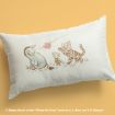 White pillow featuring classic Winnie the Pooh characters Eeyore, Piglet, and Tigger joyfully playing with a pink butterfly, set against a light yellow background.