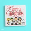 A Peanuts illustration shows four characters singing carols with “Merry Christmas” in red script above them and Snoopy standing next to them, all on a white square background with a blue backdrop.