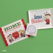 Peanuts cards and art: a holiday card with Peanuts characters, a framed “A Charlie Brown Christmas” print, and a small envelope with a blue Peanuts-themed stamp, all on a green background.