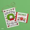 A Christmas towel with Snoopy in a wreath reads, “I’m Dreaming of a Farmhouse Christmas.” Next to it, a holiday card says, “Home for the holidays!” with Peanuts characters by a decorated tree.