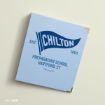 A light blue book or binder with a “Chilton” pennant design, reading “EST. 1803, Preparatory School, Hartford, CT, Gilmore Girls,” with gold corner accents on a light background.