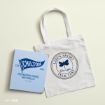A white tote bag with “Life’s short, talk fast, Gilmore Girls” text and butterfly graphic lies next to a blue Chilton Preparatory School notebook on a cream surface.