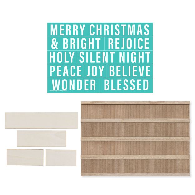 A teal sign with festive words, blank wooden slats, and a wooden board with horizontal slots, for creating a customizable holiday message.