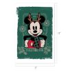 Mickey Mouse wearing antlers and a scarf stands in front of a green background with snowflakes and pinecones. Text at the bottom says “YULETIDE FUN.” Image size is 17 inches by 11 inches.