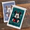 A festive cloth banner shows Mickey Mouse wearing reindeer antlers, holding a mug, and dressed in winter clothes with “YULETIDE FUN” text. Snowflakes and holiday patterns decorate the background.