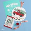 Disney-themed Christmas crafts featuring Mickey and Minnie Mouse: a red truck carrying a tree, “Home for Christmas!” sign, “Oh what jolly” card, striped ribbon, red paint, and a green print on a blue background.