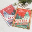 Two National Lampoon’s Christmas Vacation wall signs with a wintry forest design, shown with pine branches and ornaments on a marble surface.