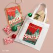 A white tote bag and a hanging sign both featuring National Lampoon’s Christmas Vacation artwork, displayed with two small wrapped gifts and two decorative Christmas ornaments.