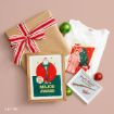 A gift wrapped in brown paper with a red and white striped bow, a white A Christmas Story t-shirt, and two framed prints featuring the movie’s leg lamp and Red Ryder BB gun.